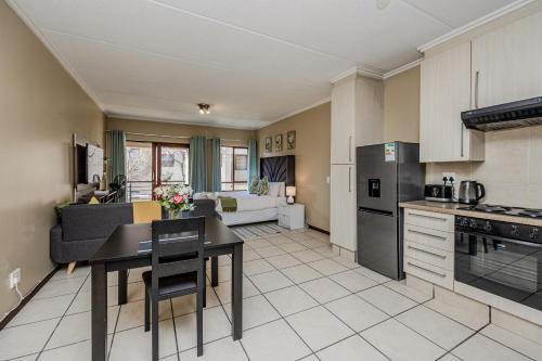 a kitchen and living room with a table and chairs at Grace Haven in Sandton