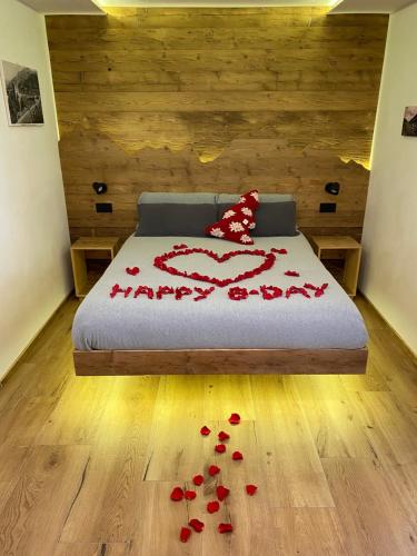 a bedroom with a bed with red rose petals on the floor at Lidia & Orfeo in Bormio
