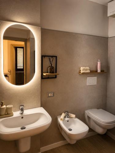 a bathroom with a sink and a toilet and a mirror at Siham lake home in Verceia