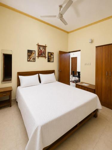 a bedroom with a large white bed with a ceiling at Shiva Valley Retreat in Calangute