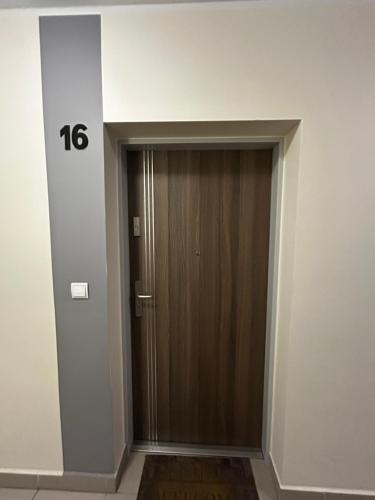 a wooden door in a room with the number at Apartament w Dolinie Baryczy in Milicz