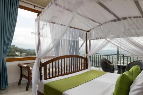 a bedroom with a canopy bed and a balcony at Sunset Heaven Boutique in Kandy