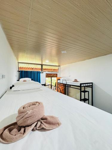 a bedroom with a bed with a towel on it at Glowhaven Hostel in Sigiriya
