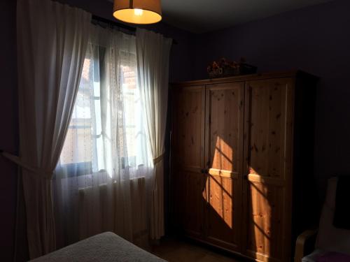 a bedroom with a window and a dresser and a curtain at La Senda Del Duratón in Sebúlcor