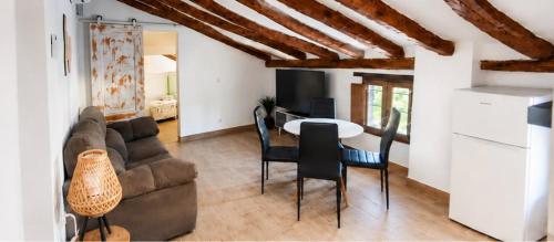 a living room with a couch and a table with chairs at Origen&Madera in Alcalá del Júcar