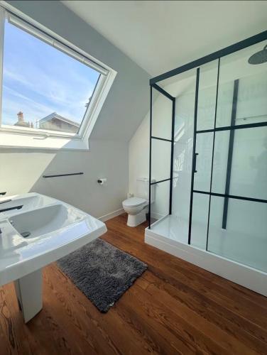 a bathroom with a sink and a glass shower at La Côte in Granville