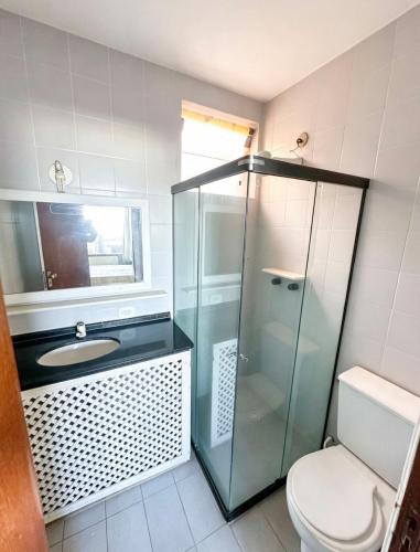 a bathroom with a glass shower and a toilet at Beachfront suite right on the sand in Cabo Frio