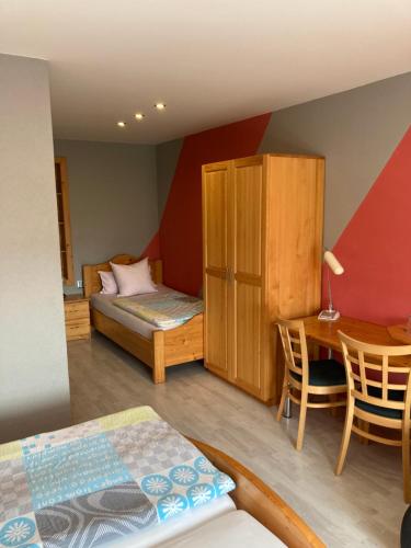 a bedroom with a bed and a desk with a table at Penzion Kohout in Nýrsko