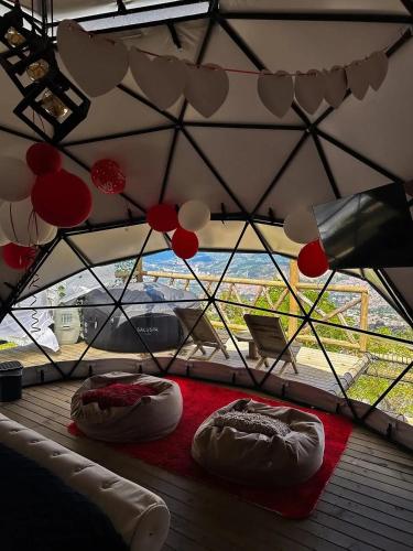 ein Zimmer mit zwei Betten in einem Zelt mit einem Fenster in der Unterkunft NatuGlamp in Medellín