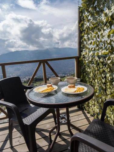 Ein Tisch mit zwei Tellern Essen auf einem Balkon in der Unterkunft NatuGlamp in Medellín
