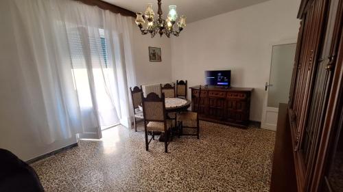 a dining room with a table and chairs and a chandelier at Appartamento in Via Cardella in Pitigliano