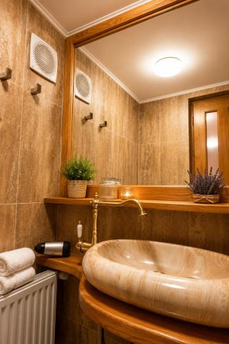 a bathroom with a large tub and a mirror at History Apartments Cetății in Sibiu