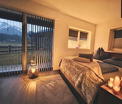 a bedroom with a bed and a large window at Apartment WEITBLICK in Wald im Pinzgau