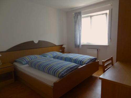 a bedroom with a bed and a window and a desk at Renates Ferienwohnungen in Meltina