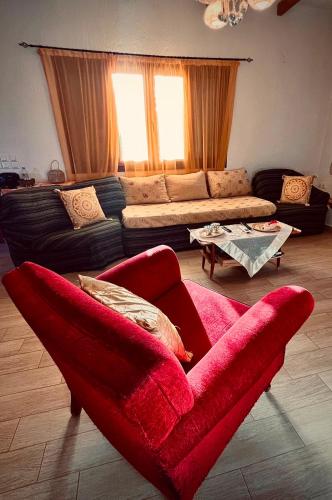 a living room with a red chair and a couch at Nancy in Politika