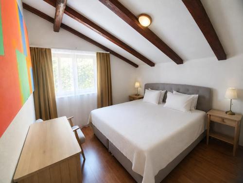 a bedroom with a white bed and a window at Apartments Micic in Lovran