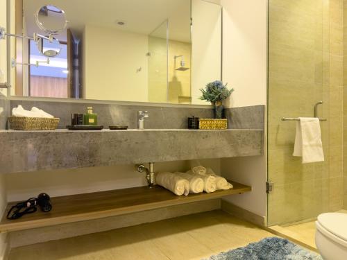 a bathroom with a sink and a toilet and a mirror at Loft en Zibata con Vista Alberca y Gym in La Cañada