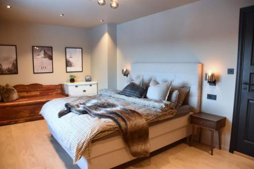 a bedroom with a bed with a blanket on it at Stort hus med jaquzzi in Geilo