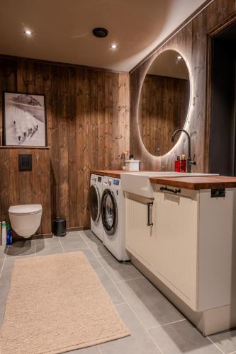 a bathroom with a washing machine and a sink at Stort hus med jaquzzi in Geilo