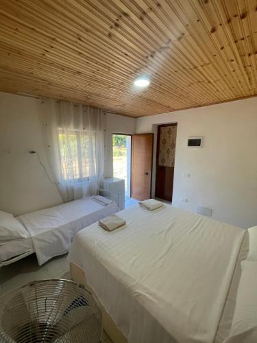 a bedroom with two beds and a fan in it at Bujtina Dalmacia 2 in Shkodër