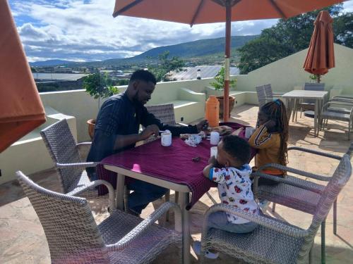 a man and two children sitting at a table at Lions adventure in Narok