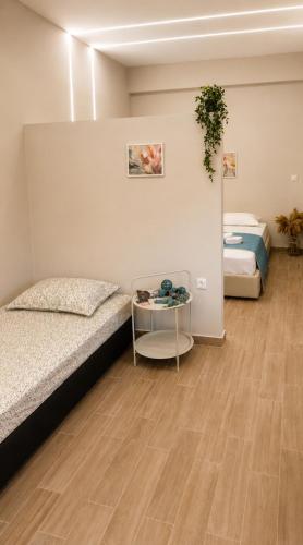 a room with two beds and a table in it at Galazio suites 3 Seaside in Salamina