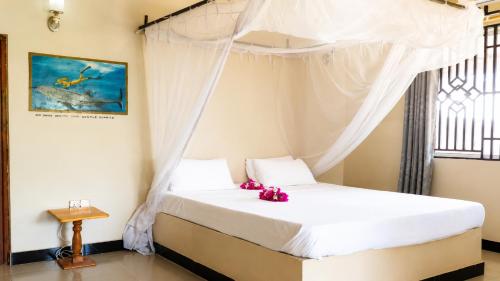 a bedroom with a bed with a canopy at Meremeta Lodge in Utende