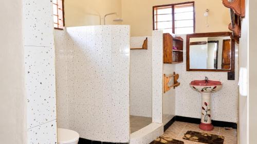 a bathroom with a toilet and a sink at Meremeta Lodge in Utende