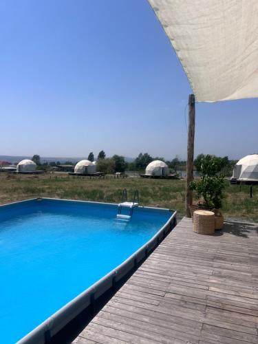 a large blue swimming pool with a wooden deck at Chadir yurd glamp in İsmayıllı