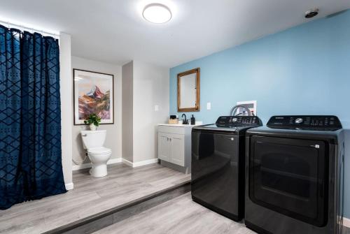 a kitchen with a stove and a washer and dryer at 5BR Hocking Hills Cabin, Arcade, Forest Views in South Bloomingville