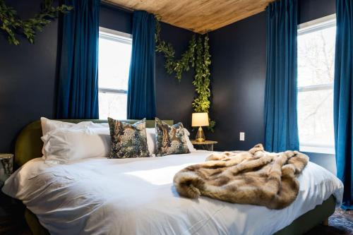 a bedroom with a large bed with blue curtains at 5BR Hocking Hills Cabin, Arcade, Forest Views in South Bloomingville