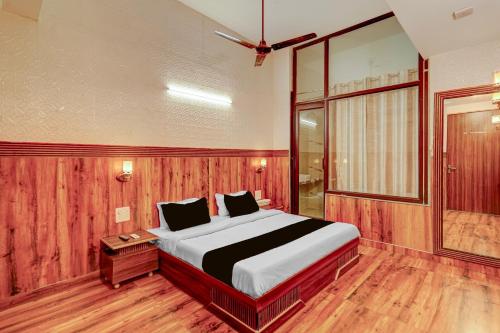 a bedroom with a large bed and a window at HOTEL O SAFFRON in Meerut