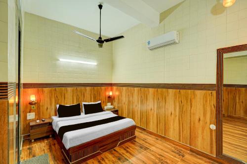 a bedroom with a large bed and a glass door at HOTEL O SAFFRON in Meerut