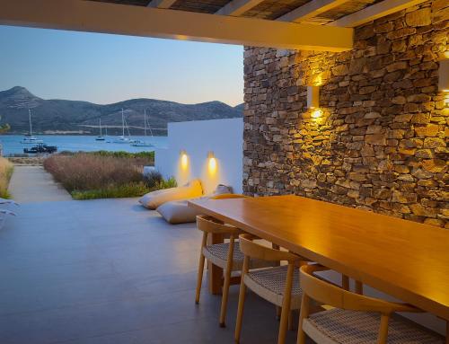 a dining room with a wooden table and chairs at Farous seaside sunset villa II in Antiparos