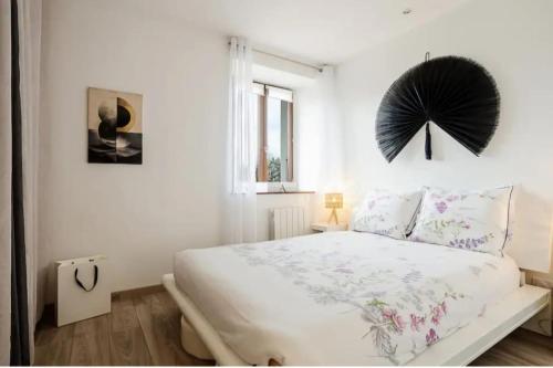 a white bedroom with a large bed and a window at Entre lac-montagnes et frontière in Contamine-sur-Arve