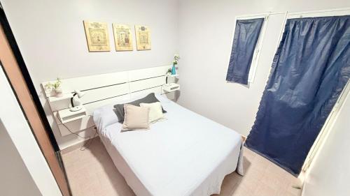 a small bedroom with a white bed and a window at AltaMar in Playa Unión