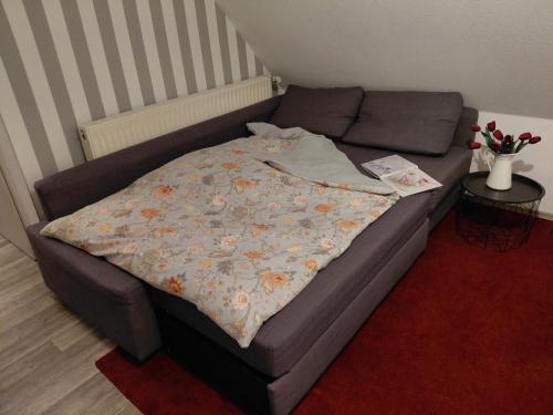 a bed with a blanket on it in a room at Ferienwohnung Laeticia in Stedesdorf