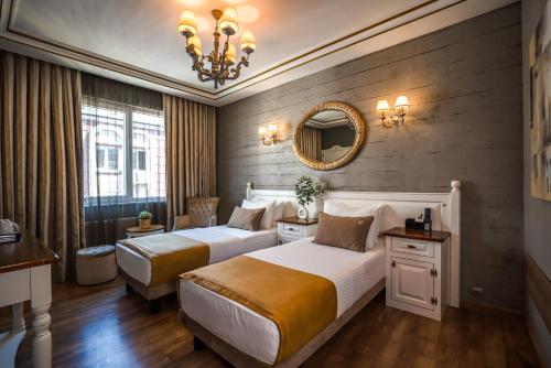 a hotel room with two beds and a mirror at My Dora Hotel in Istanbul