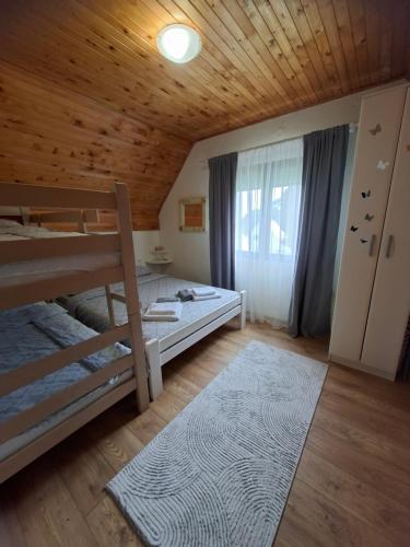 a bedroom with a bunk bed and a wooden ceiling at Sunrise in Žabljak
