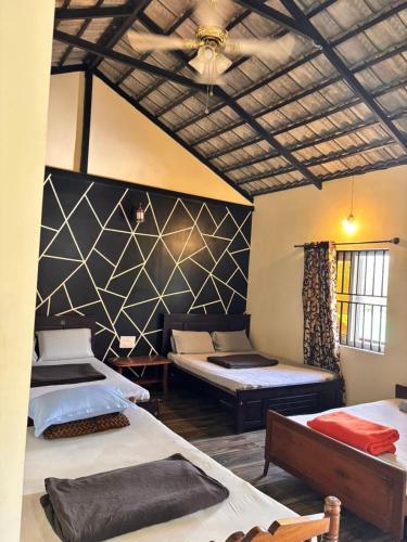a bedroom with two beds and a wall with at Coorg Annu Stay in Madikeri