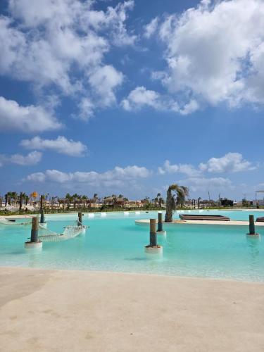 a pool of blue water with palm trees on a beach at D-bay north coast 4 bed rooms villa minimum stay 3 nights in Zāwiyat ‘Abd al Mun‘im