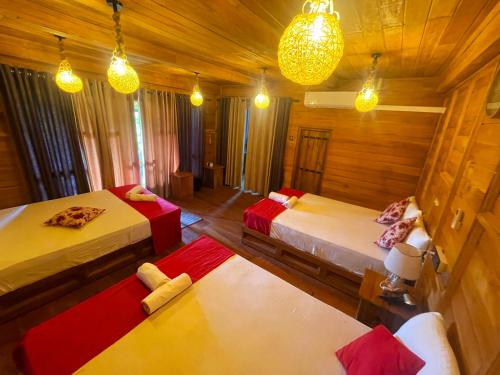 a room with two beds and two tables and lights at Ama Villa - Habarana in Habarana