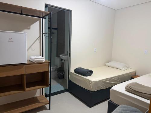 a small room with two beds and a mirror at Pousada SMART AIRPORT 10 min GRU in Guarulhos