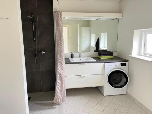 a bathroom with a sink and a washing machine at Bright and quiet townhouse in Bellinge