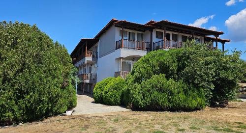 a white building with trees in front of it at Sithonia Mare Hotel in Gerakini