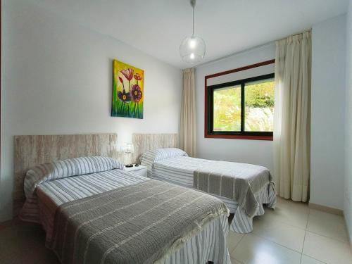 a hotel room with two beds and a window at Gran Paraíso Raxo in Raxó