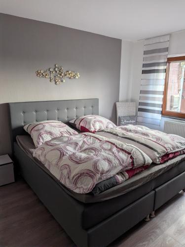 a bedroom with a large bed with avertisementatronatronstrationstrationstration at Ferienwohnung Bahnhof Ehr in Halsenbach