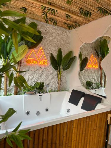 a bathroom with a white tub with plants on the wall at Dilijan House in Dilijan