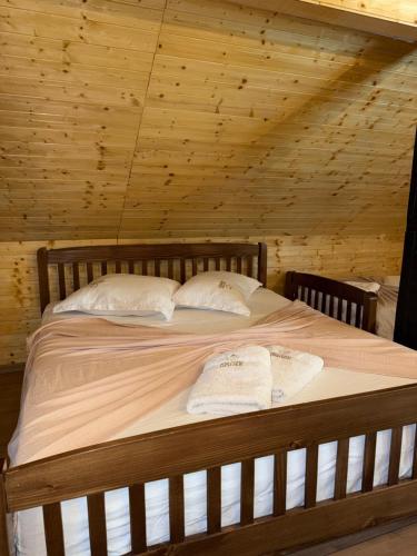 a bed in a wooden room with two towels on it at Riza Guest House in Pukë