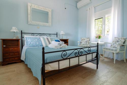 a blue bedroom with a bed and a chair at Mareliva Retreat in Trinísia